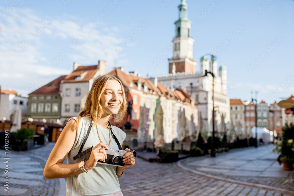 Porait of a young woman tourist traveling on the old Market sqaure in Poznan city during the morning