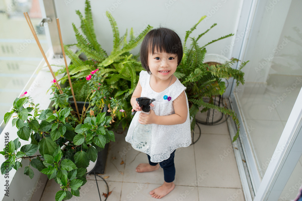 孩子在照顾植物。可爱的小女孩在浇花