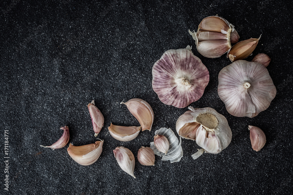 Close up the group of garlic on black stone texture , top view or overhead shot