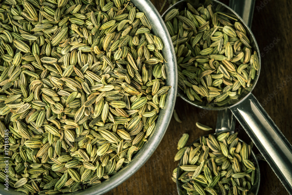 close up the fennel seed in  spoon on brown wooden table