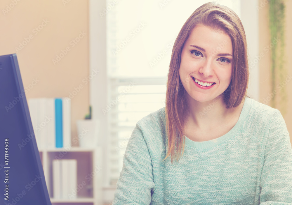 Happy young woman smiling in her home office