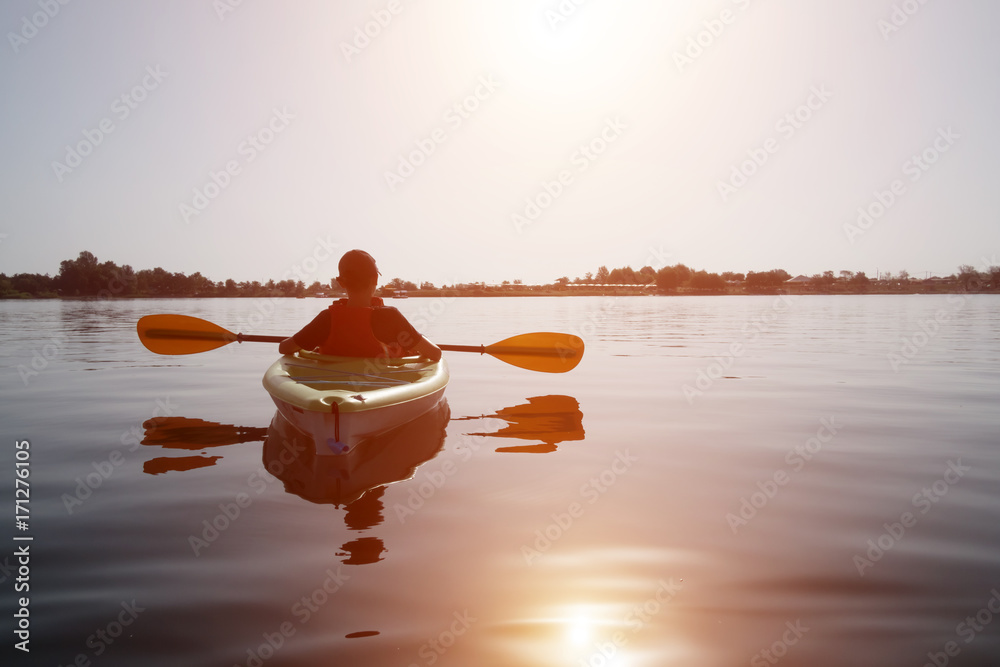 Boy in life jacket on green kayak