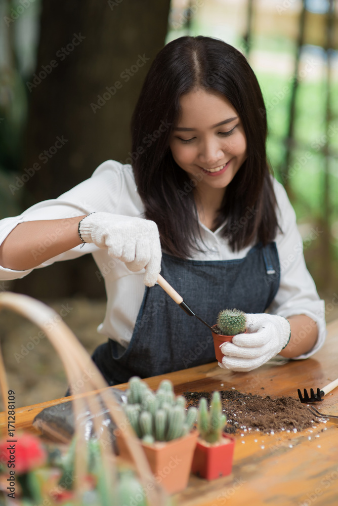 Portrait young Asian girl planting little cactus in a pot