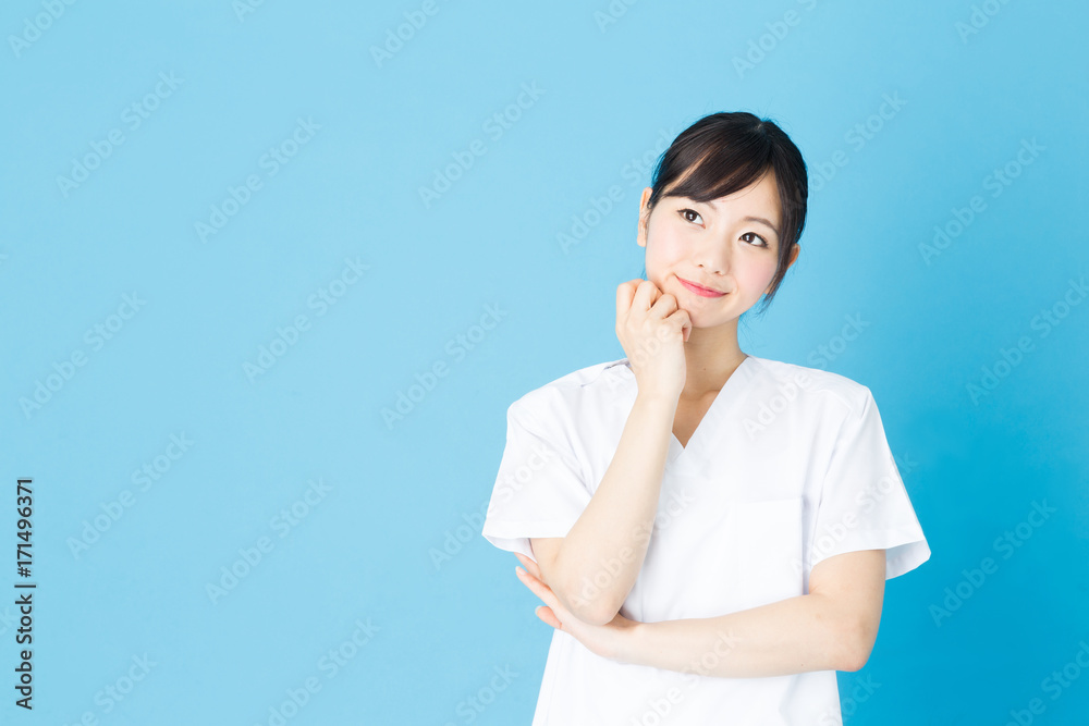 portrait of asian nurse isolated on blue background