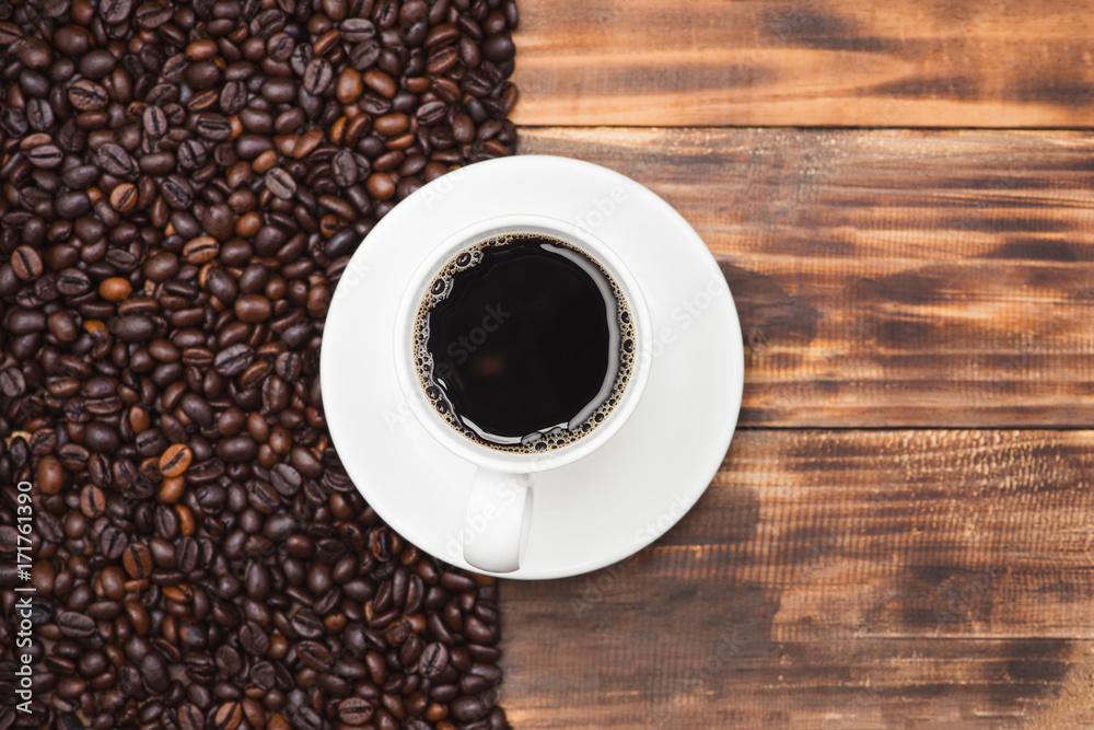 Coffee cup and beans on a rustic background