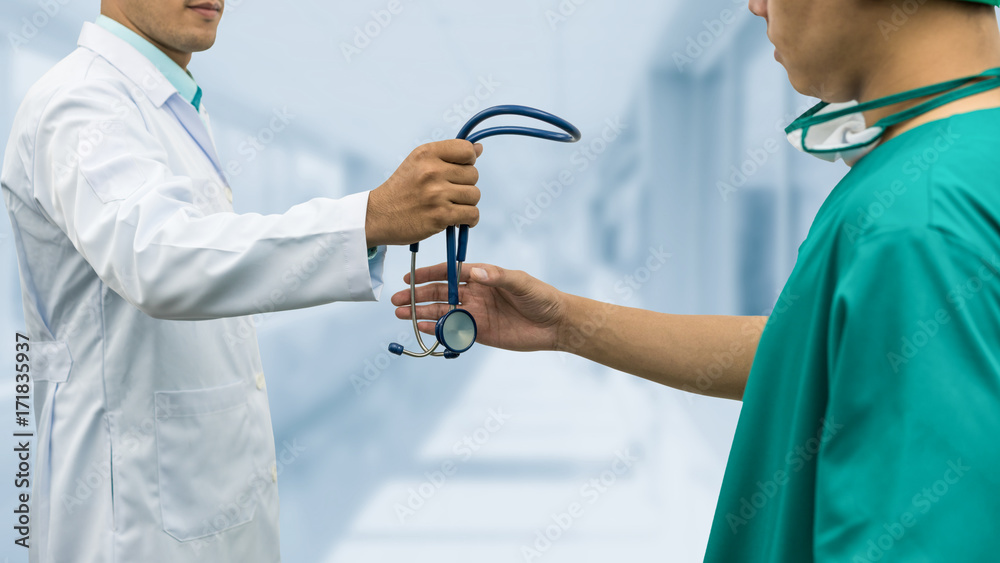 Doctor giving stethoscope to surgeon (Referral)