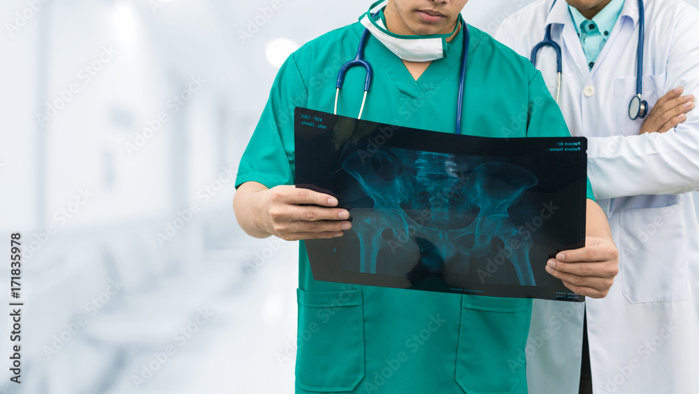 Surgeon and doctor looking at x-ray film.