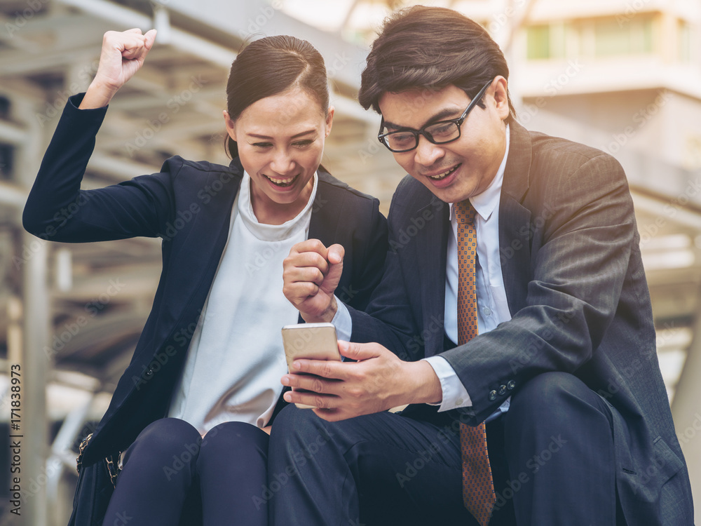 Happy business man and woman looking at phone