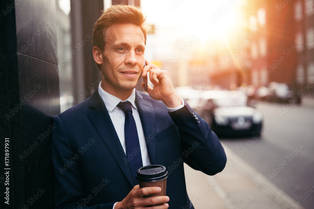 Smiling executive talking on a cellphone in the city