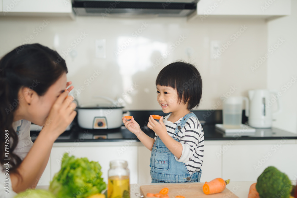 厨房里有一个幸福的家庭。母女俩正在准备蔬菜和水果。