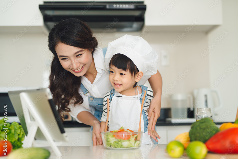 厨房里有一个幸福的家庭。母女俩正在准备蔬菜和水果。