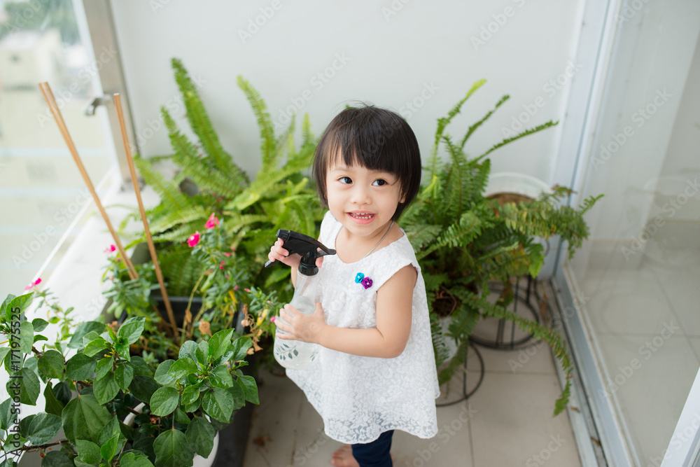 孩子在照顾植物。可爱的小女孩在浇花