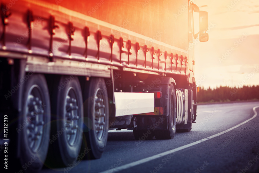 asphalt road with a truck. lorry moving on sunny evening