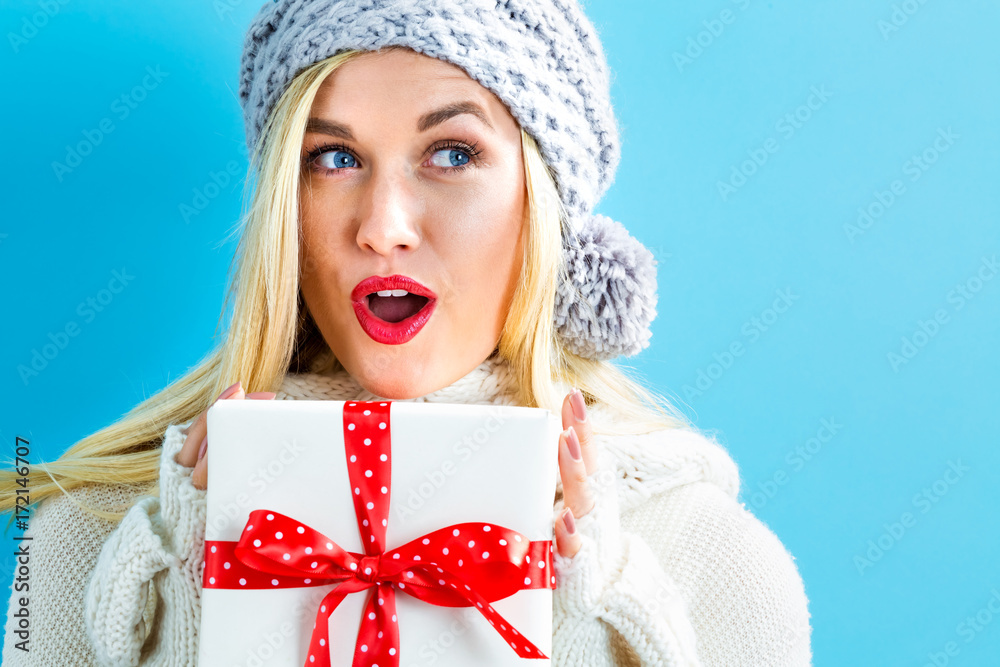 Happy young woman holding a Christmas present