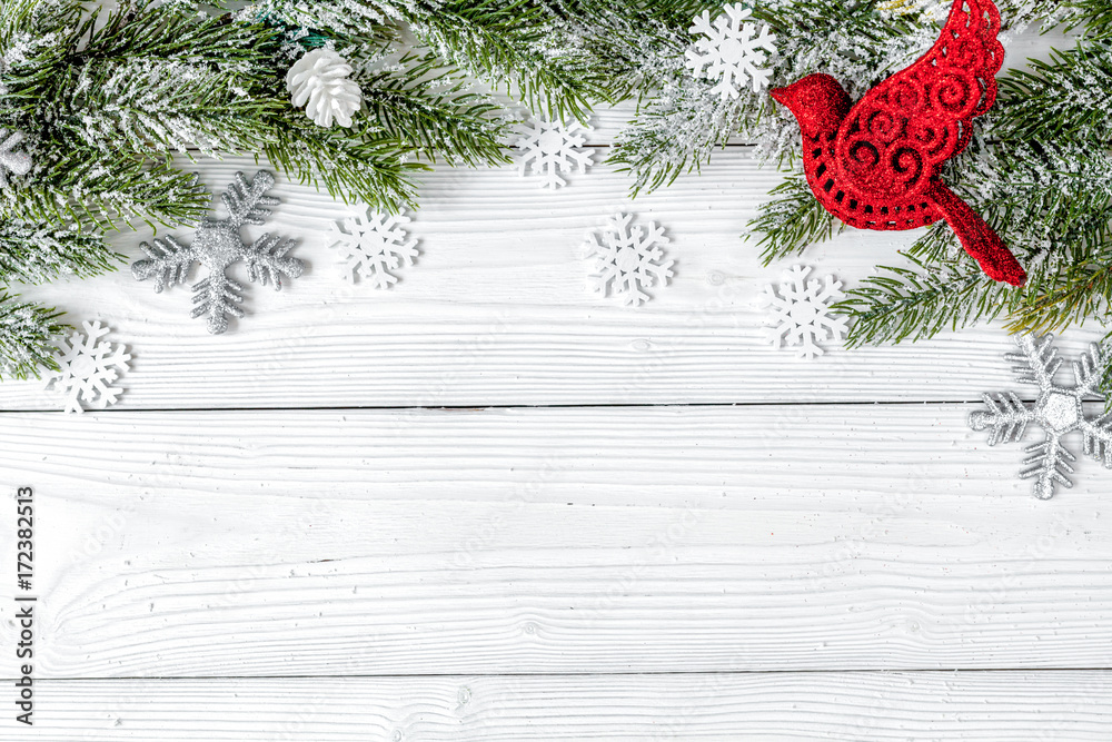 Christmas toys and spruce branches on wooden background top view