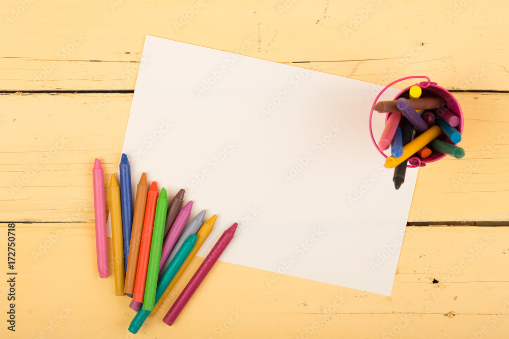 colored crayons and blank page on the desk