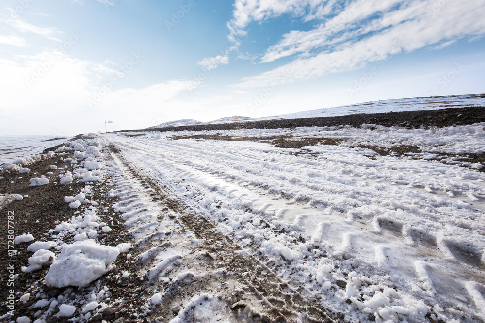 country road and hills with white snow