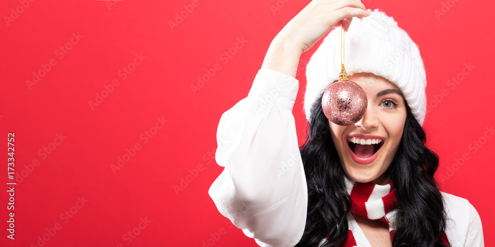 Happy young woman holding a Christmas bauble