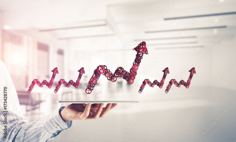 Close of businessman holding tablet pc with progressing graph ic