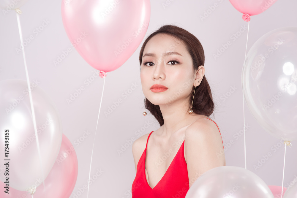 Asian beautiful woman in red dress with pastel balloons