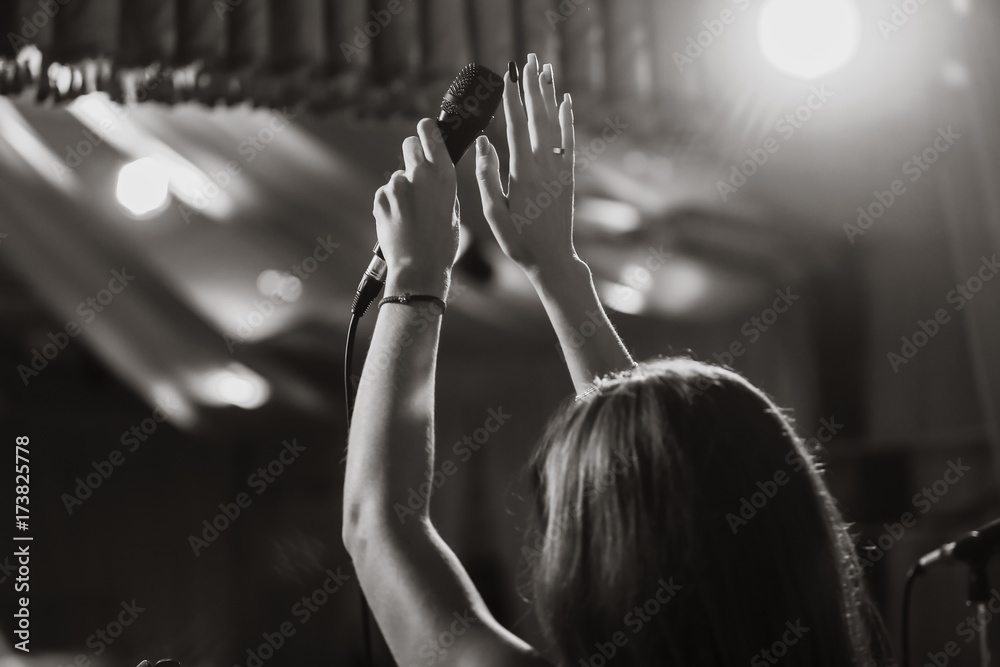 Microphone in female hands close-up. Black and white photo. A pub. Bar. A restaurant. Classical musi