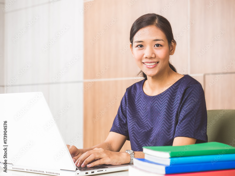 Young asian businesswoman working on laptop at office during, smiling and happy working.