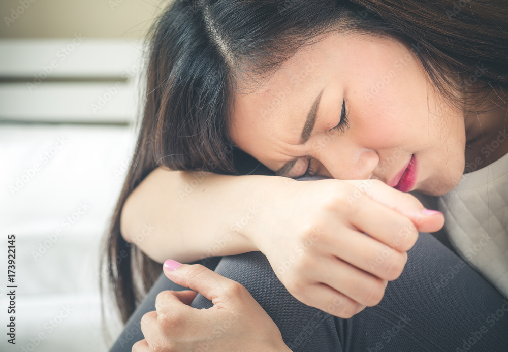 年轻的亚洲女人哭泣，感到悲伤和沮丧。