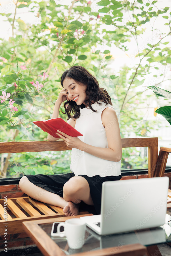 漂亮的亚洲女孩在家里的桌子上写笔记