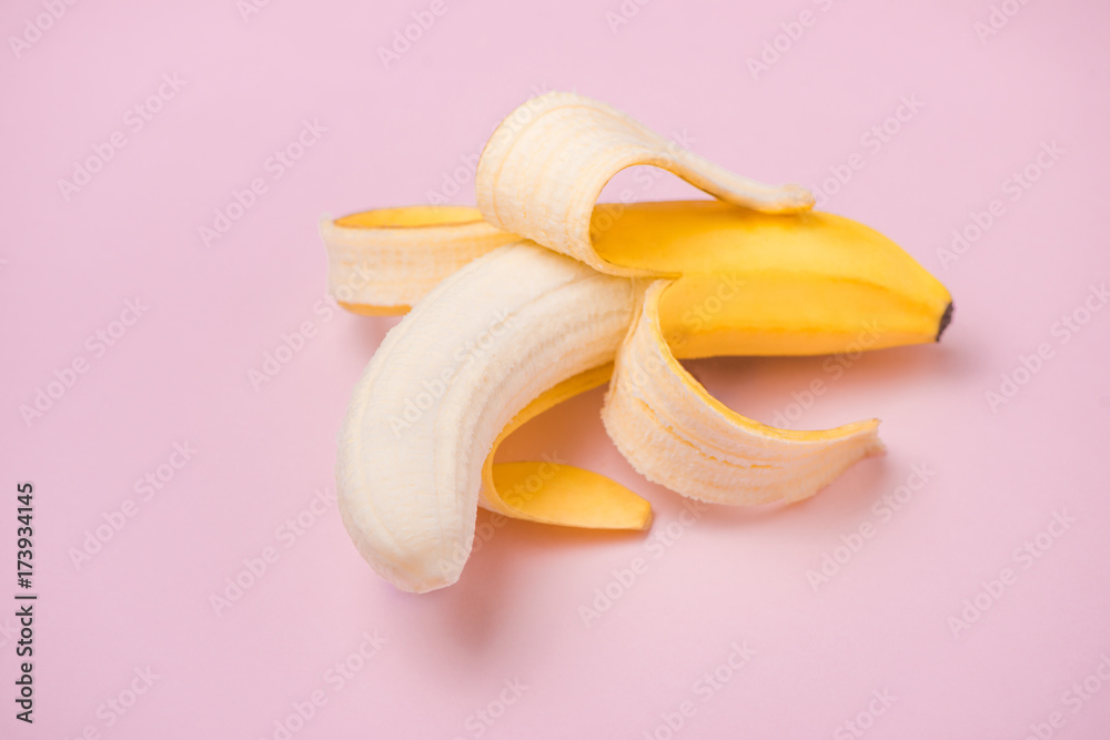 Fresh peeled banana on pink background