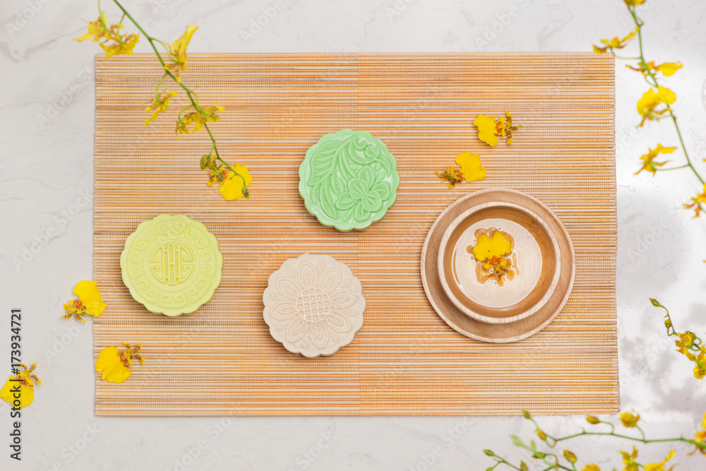 Sweet color of snow skin mooncake. Traditional mid autumn festival foods with tea on table setting.