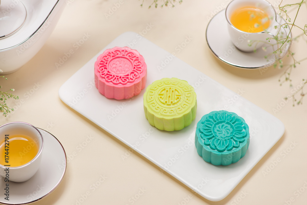 Colorful snow skin mooncake with tea pot on pink background