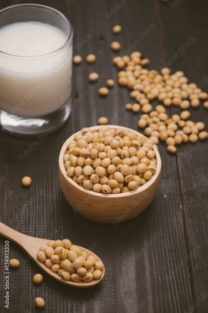 Glass with soy milk and soy bean on wooden background