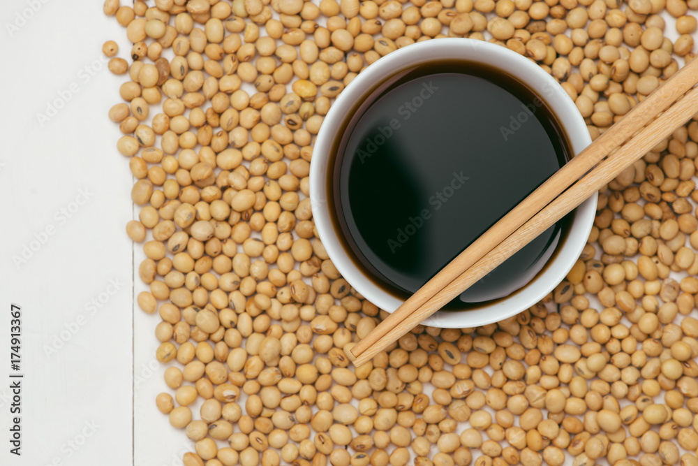 Soy sauce and soy bean with chopsticks on wooden table