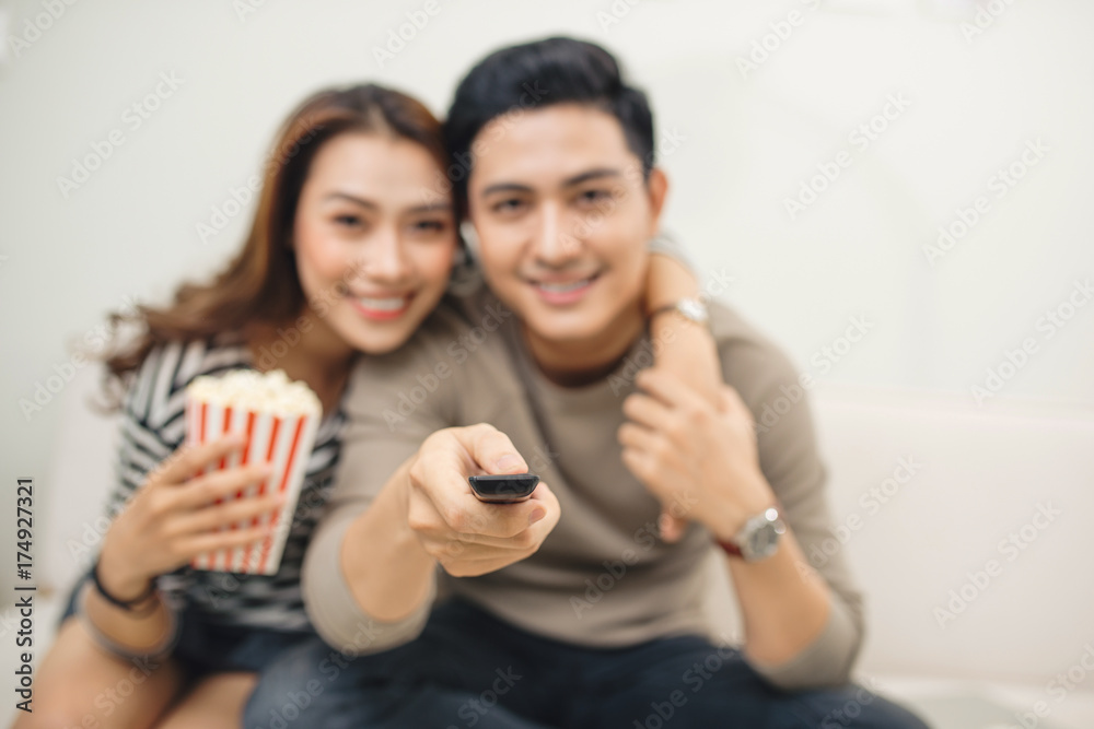 Attractive couple watching tv on the couch at home in living room