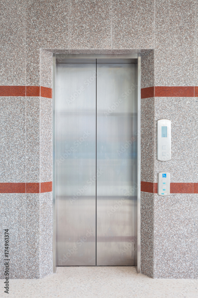 Modern steel elevator with closed doors in business building office.