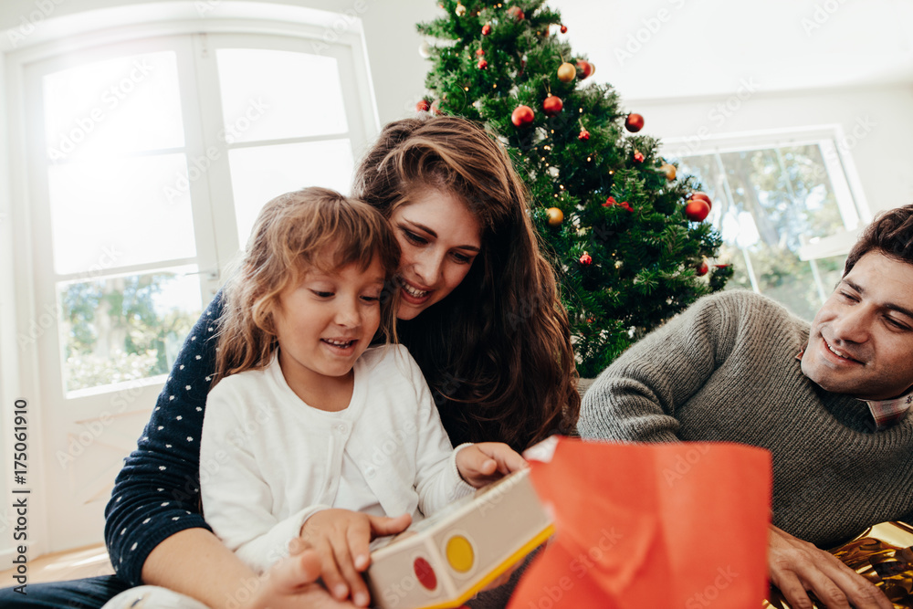 Little girl having  a look at her Christmas gift.