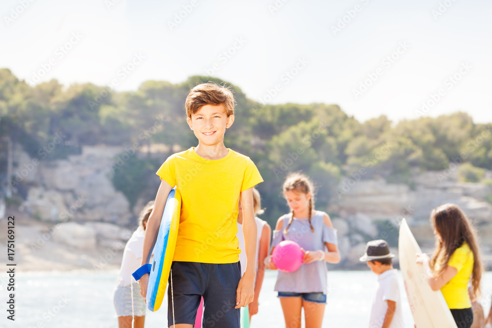 Boy stand on the beach with body board