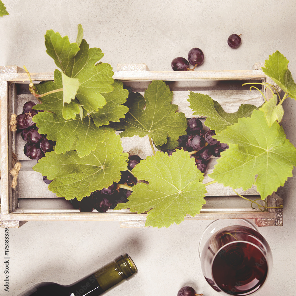 Wine and grapes over grey marble background