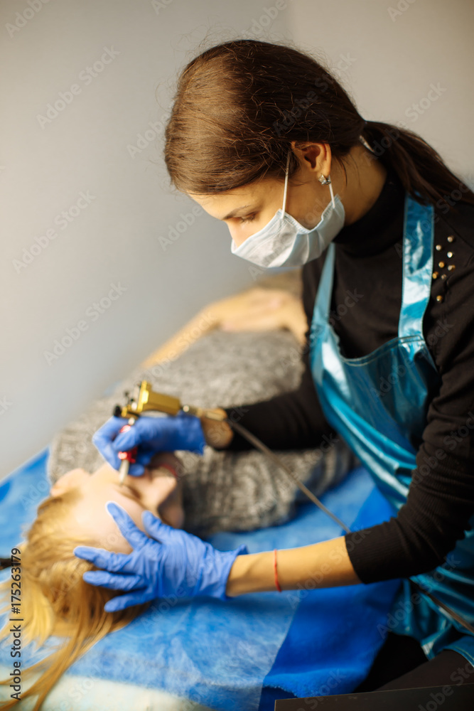 Permanent Makeup For Eyebrows. Closeup Of Beautiful Woman With Thick Brows In Beauty Salon. Beautici