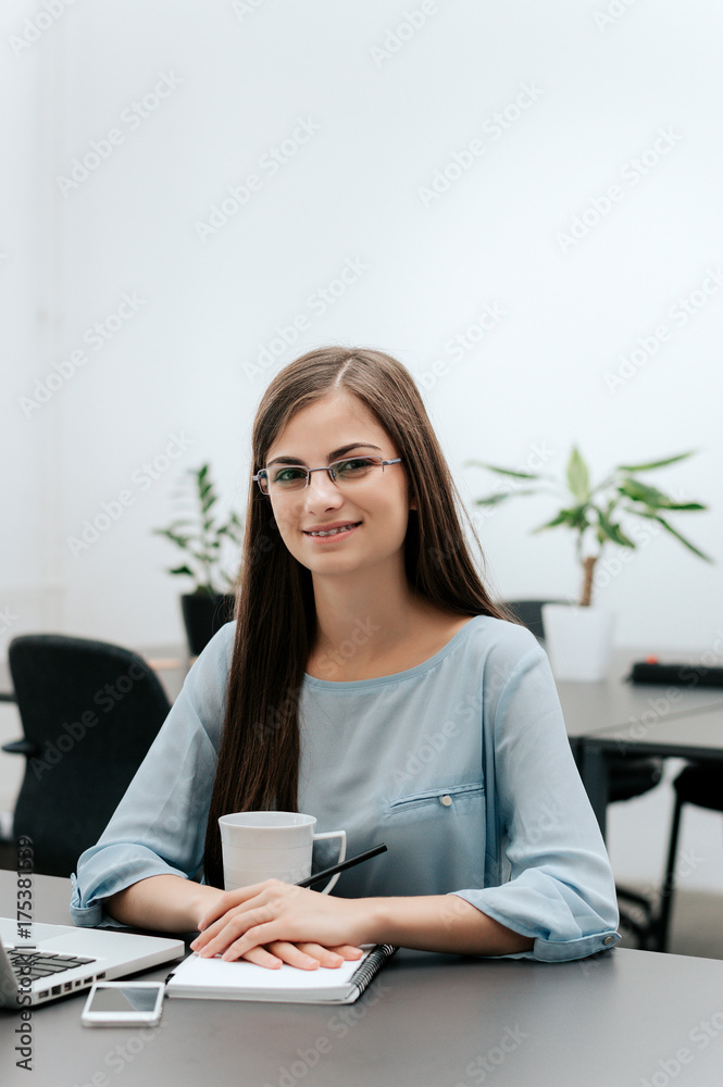 快乐成功的女商人戴着眼镜看着镜头微笑的肖像。