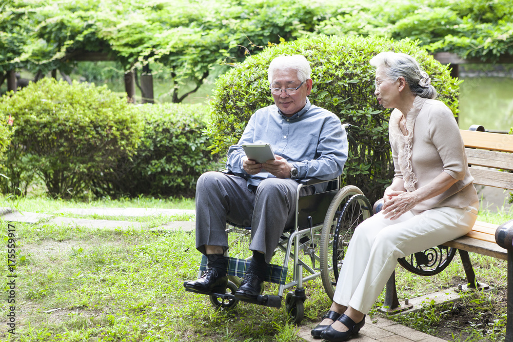 An old couple is using a tablet