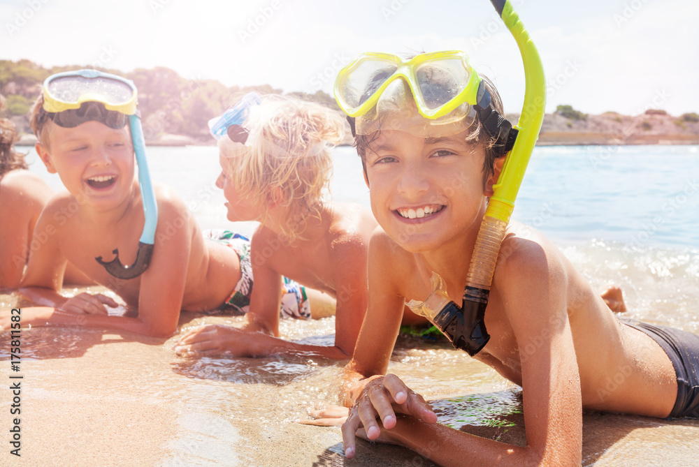 Group of laughing kids in scuba mask on the beach