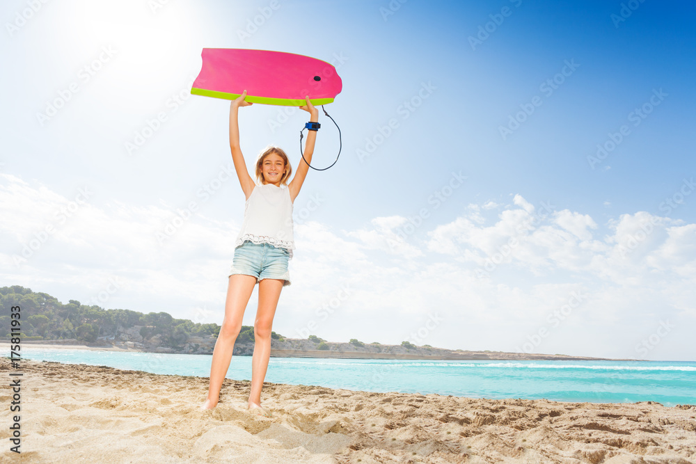 海滩上漂亮的金发女孩拿着冲浪板