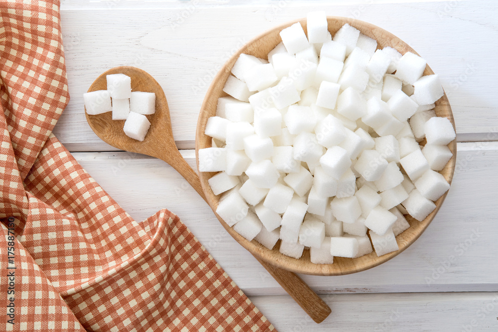 Close up the sugar cubes  in wooden bowl on  table , top view or overhead shot