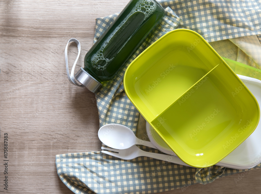 green empty lunch box wrapped  on wooden table , top view or overhead shot , green food concept