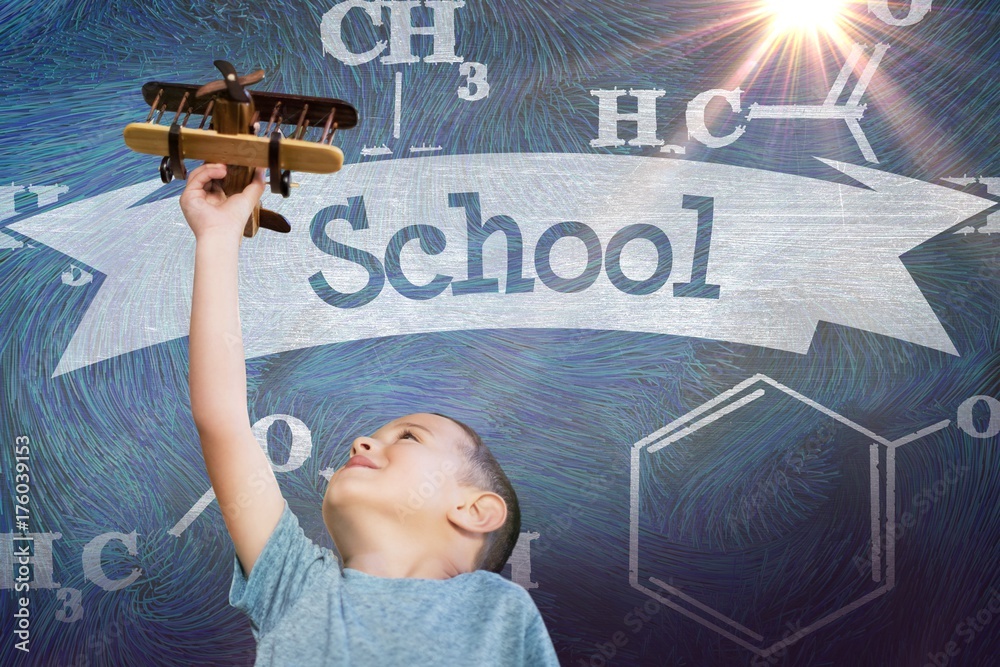 Composite image of boy holding wooden toy airplane