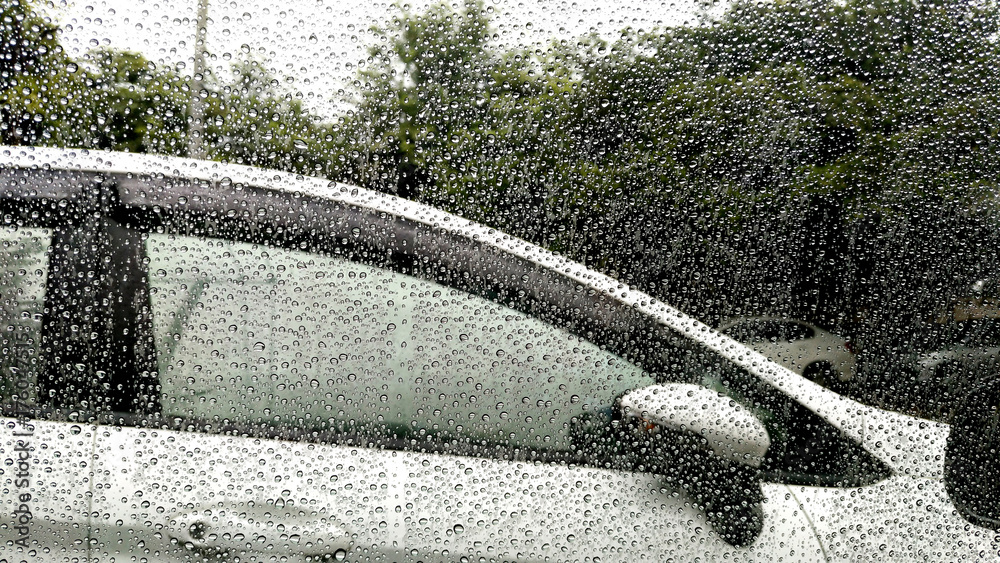 雨点落在车窗上，背景是汽车。