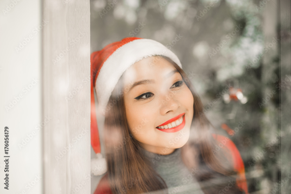 快乐的年轻亚洲女人在圣诞树旁庆祝新年