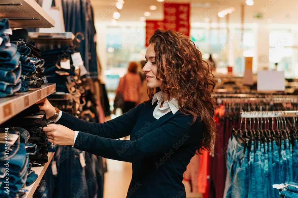 Shopper looking at clothing indoors in store.