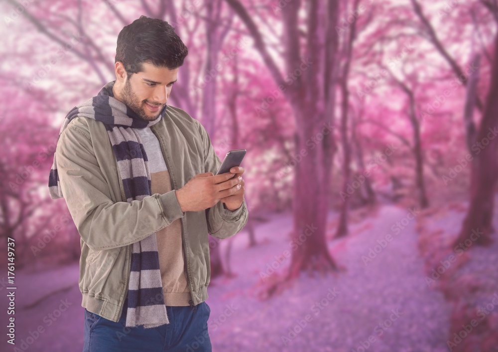 Man in Autumn with phone in forest